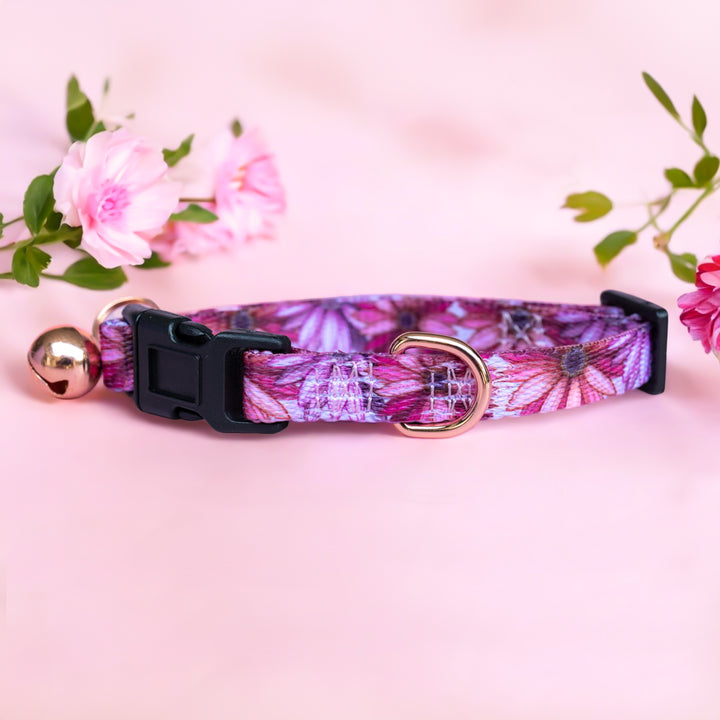 Perfect Petals Puppy Collar by Dizzy Dog Collars This adorable puppy collar features a vibrant floral pattern in pink and purple tones. It includes a quick-release buckle, a rose gold D-ring, and a small bell to keep track of your playful pup. The collar is adjustable, ensuring a comfortable fit as your puppy grows. Made from durable, high-quality materials, it combines style and practicality, making it perfect for daily wear and special occasions.